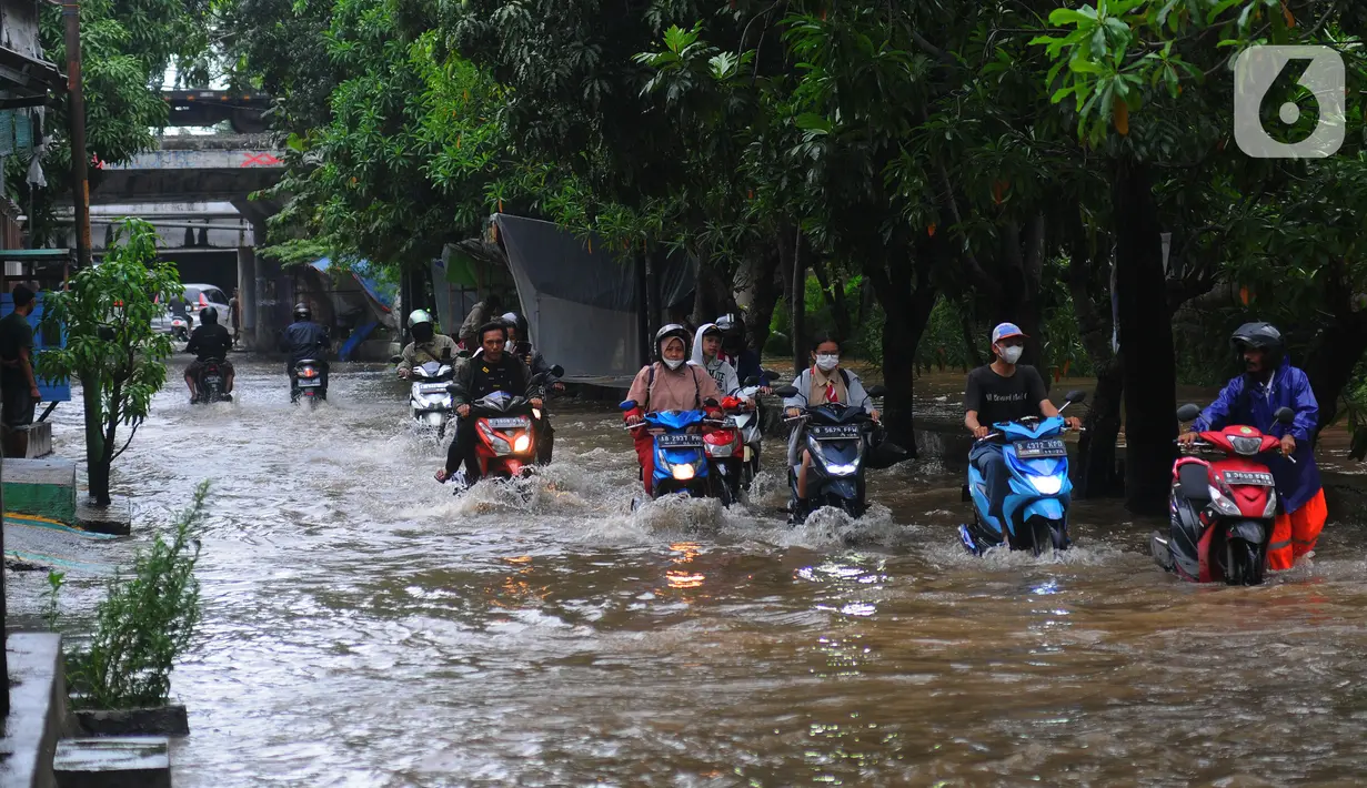 Sejumlah pengendara motor melintasi banjir di Jalan Benteng,  Duta Kranji, Kalibaru, Bekasi, Jawa Barat, Jumat (24/2/2023). Jalan yang dilalui oleh para pengendara masih digenangi air ditambah dari luapan kalibaru Duta Kranji akibat hujan deras yang mengguyur Kota Bekasi sejak Kamis (23/2/2023) malam. (merdeka.com/Imam Buhori)