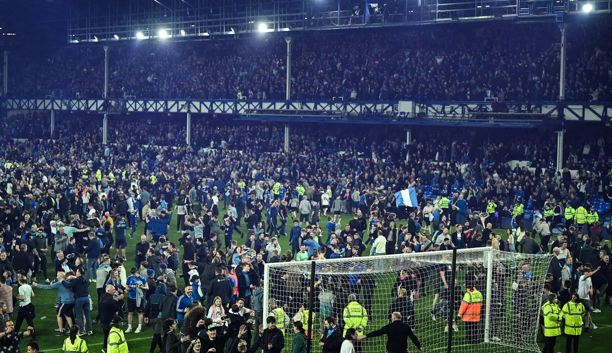 Suporter Everton menyerbu lapangan untuk merayakan akhir pertandingan Liga Inggris antara Everton dan Crystal Palace di Goodison Park di Liverpool, Inggris, 19 Mei 2022. Everton berhasil menang lewat come back dramatis 3-2 dan keluar dari zona degradasi Liga Inggris. (AFP/Oli Scarff)