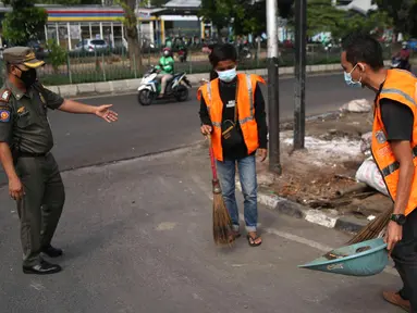 Petugas Satpol PP mengawasi pelanggar saat razia masker di depan Stasiun Klender, Jakarta, Selasa (10/5/2022). Pemerintah memastikan akan terus memperpanjang masa pemberlakuan pembatasan kegiatan masyarakat (PPKM) se-Indonesia hingga waktu yang belum ditentukan. (Liputan6.com/Faizal Fanani)