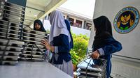 Para siswa mengambil nampan berisi makanan yang dipasok oleh program Makan Bergizi Gratis (MBG) di sebuah sekolah dasar di Banda Aceh pada Kamis 30 Oktober 2025. Program ini melibatkan berbagai pihak dan dilaksanakan secara bertahap. (CHAIDEER MAHYUDDIN/AFP)