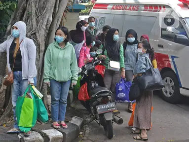 Sejumlah pasien Covid-19 Tanpa Gejala bersiap menaiki bus sekolah di Puskesmas Kecamatan Cilandak, Jakarta, Kamis (4/2/2021). Data Satgas Covid-19 per Kamis (4/2) mencatat kasus positif di Indonesia bertambah 11.434 orang. (Liputan6.com/Herman Zakharia)