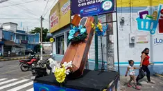 Warga berjalan dekat peti mati dengan tulisan, "Anda memutuskan, di rumah atau di dalam kotak ini", sebagai bagian dari kampanye pemerintah setempat di jalan-jalan kotamadya Escuintla, Guatemala City pada 21 Juli 2020. Kampanye itu sebagai upaya menghentikan penyebaran COVID-19. (Johan ORDONEZ/AFP)