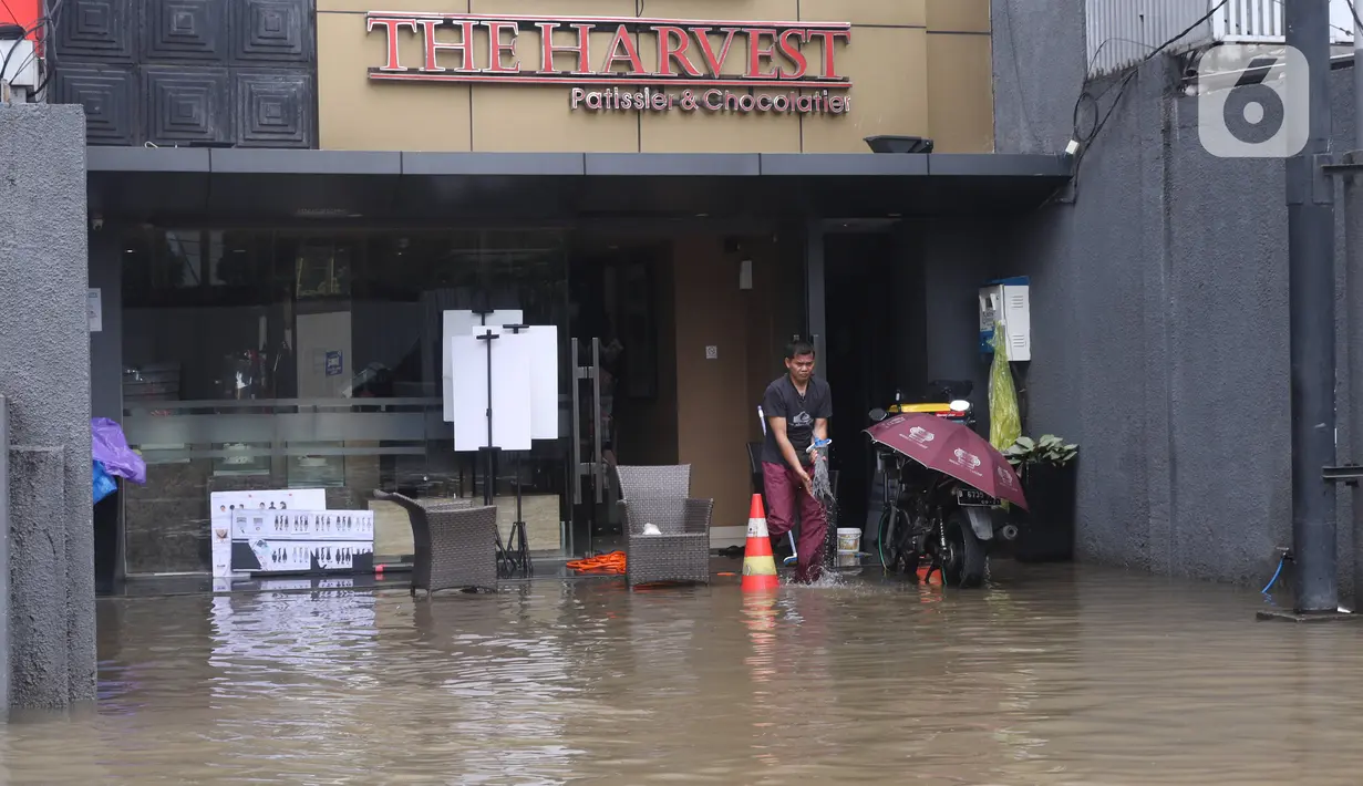 Pekerja membersihkan pertokoan yang terendam banjir di Kawasan Bendungan Hilir (Benhil), Jakarta Pusat, Selasa (25/2/2020). Salah satu wilayah terdampak banjir yakni kawasan Benhil hingga membuat akses jalan untuk sementara terputus.  (Liputan6.com/Angga Yuniar)