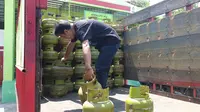 Salah seorang pegawai gas di salah pangkalan di Garut, Jawa Barat tengah menurunkan gas melon atau bersubsidi 3 kg. (Liputan6.com/Jayadi Supriadin)
