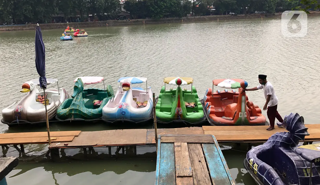 Seorang pria berjalan di sekitar Perkampungan Budaya Betawi Setu Babakan, Jakarta, Senin (22/6/2020). Danau buatan seluas 30 hektare tersebut kembali dibuka untuk umum setelah sebelumnya ditutup untuk mencegah penyebaran virus corona COVID-19. (Liputan6.com/Immanuel Antonius)