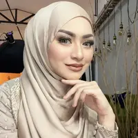 Nathalie nampak glamor dengan riasan mata shimmernya dan lipstik cokelat serasi dengan pakaian dan hijab yang dikenakan. Credit: Instagram (@nathalieholscher)