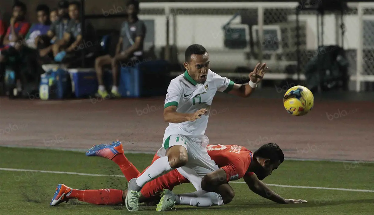 Gelandang Timnas Indonesia, Rizky Pora, terjatuh saat berebut bola dengan pemain Singapura pada laga Piala AFF 2016 di Filipina, Jumat (25/11/2016). Indonesia tertinggal 0-1 dari Singapura. (Bola.com/Nicklas Hanoatubun)