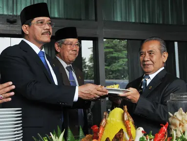 Ketua Mahkamah Agung Hatta Ali (tengah) memberikan potongan tumpeng ke hakim tertua di Mahkamah Agung seusai upacara peringatan HUT Mahkamah Agung ke-70 di Jakarta, Rabu (19/8/2015). (Liputan6.com/Herman Zakharia)