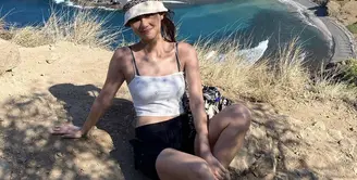 Berlibur ke Pulau Komodo, Gege Elisa tampil dengan spaggeti strap putih untuk atasan dipadukan celana pendek hitam. Ia tampil dengan bukcet hat putihnya. Credit: @gegeelisa94