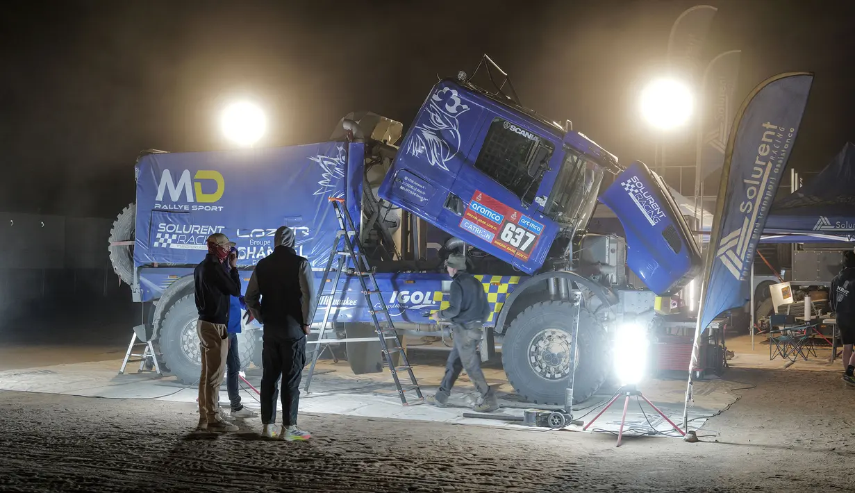 Sejumlah mekanik tim Solurent Racing tengah mempersiapkan mobil menjelang Reli Dakar 2025 pada Kamis (02/01/2025) waktu setempat di Bisha, Arab Saudi. Ajang tersebut akan berlangsung pada 3 hingga 17 Januari 2025. (AFP/Valery Hache)