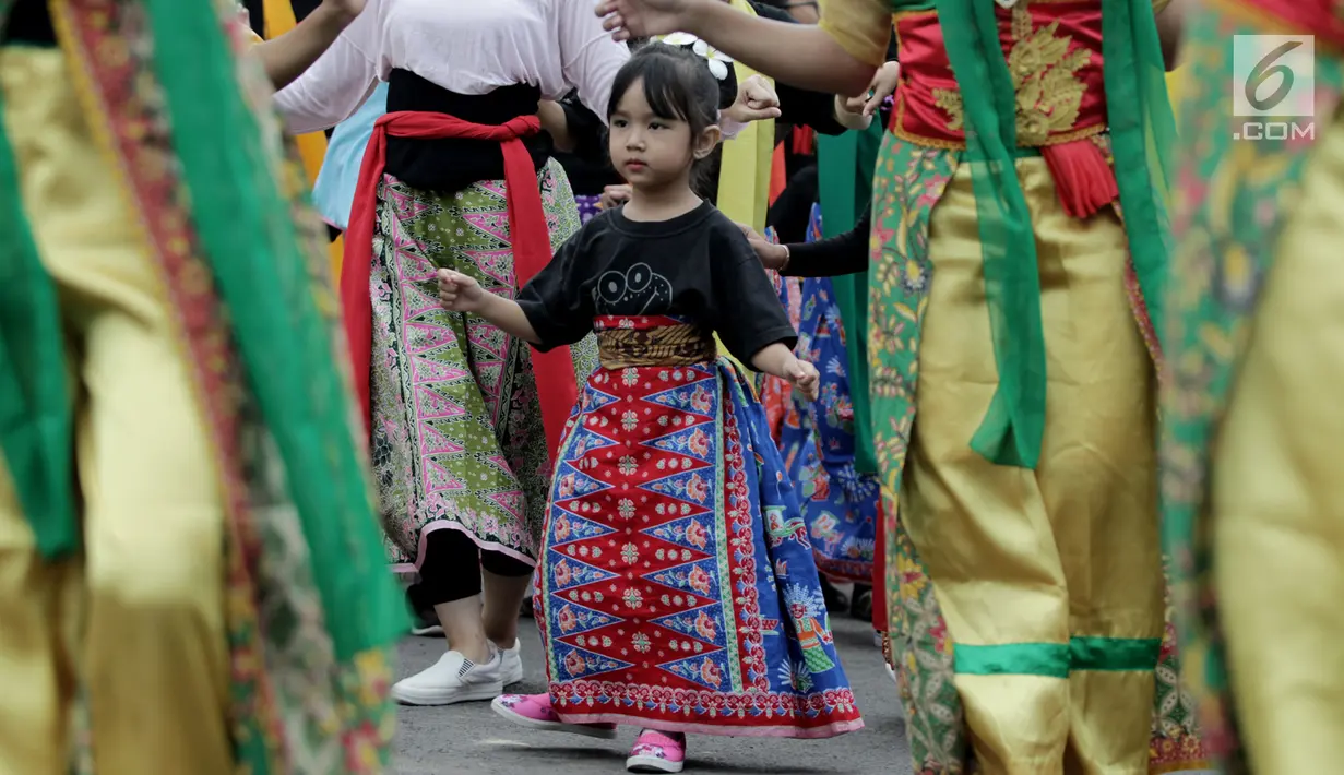 Seorang anak perempuan mengikuti flashmob tari tradisional selama acara MRT Menari di taman MRT Dukuh Atas, Jakarta, Minggu (23/12). Acara tersebut digelar dalam rangka menyambut kehadiran MRT di Jakarta. (Merdeka.com/Iqbal S Nugroho)