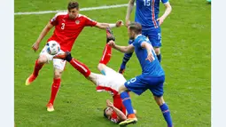 Pemain Austria, Marcel Sabitzer, terjatuh saat berebut bola dengan pemain Islandia, Gylfi Sigurdsson, pada laga terakhir Grup F Piala Eropa 2016 di Stade de France, Paris, Rabu (23/6/2016). (Reuters/Charles Platiau)