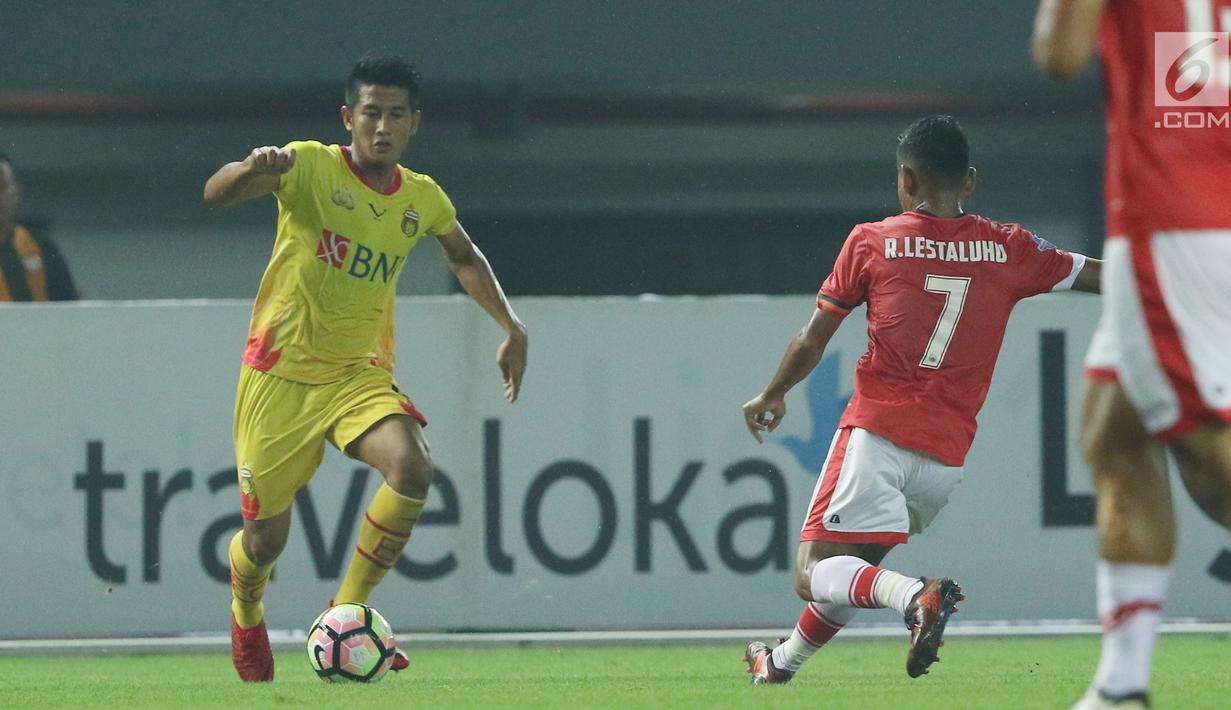 Bek Bhayangkara FC, I Putu Gede Juni Antara (kiri) saat pertandingan melawan Persija pada laga penutup Liga 1 Indonesia di Stadion Patriot Candrabhaga, Bekasi, Minggu (12/11). (Liputan6.com/Helmi Fithriansyah)