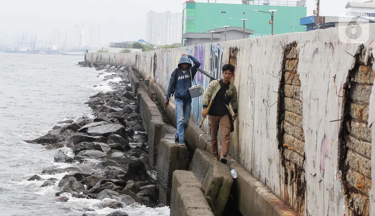 Warga sedang memancing di tanggul laut area Muara Baru, Jakarta, Selasa (4/2/2025). (detikai.com/Herman Zakharia)