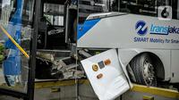 Kondisi bus Transjakarta yang menabrak separator busway di kawasan Bundaran Senayan, Jakarta, Jumat (3/12/2021). Kecelakaan mengakibatkan bagian depan bus Transjakarta rusak karena menghantam separator busway. (Liputan6.com/Faizal Fanani)