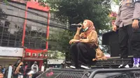 Aksi mahasiswi Qonita Syehsemala Universitas Islam Syekh-Yusuf (UNIS) Tangerang, bantu polisi tenangkan pendemo di Simpang Harmoni, Jakarta. (Liputan6.com/Radityo Priyasmoro)