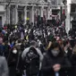 Orang-orang berjalan dengan mengenakan masker dan membawa tas belanjaan di Regent Street, setelah pelonggaran pembatasan virus corona COVID-19 menyusul berakhirnya kebijakan penguncian nasional atau lockdown kedua di Inggris, di London, Sabtu (5/12/2020). (AP Photo/Alberto Pezzali)