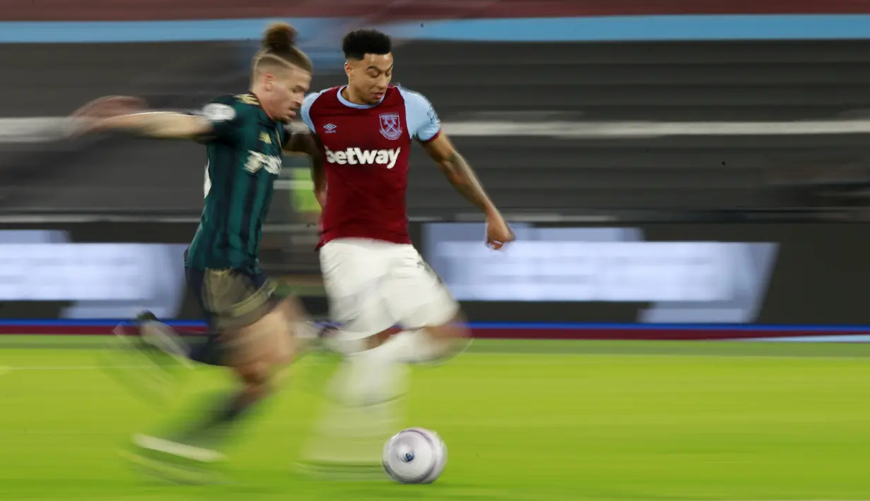 Pemain West Ham United, Jesse Lingard, berebut bola dengan pemain Leeds United, Kalvin Phillips, pada laga Liga Inggris di Stadion London, Senin (8/3/2021). West Ham menang dengan skor 2-0. (Ian Walton, Pool)