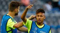 Penyerang Barcelona, Neymar berbincang dengan Gerard Pique saat melakukan sesi latihan di Olympiastadion Berlin, Jerman (5/6/2015). Barcelona akan menghadapi Juventus di Final Liga Champions. (Reuters/Kai Pfaffenbach)