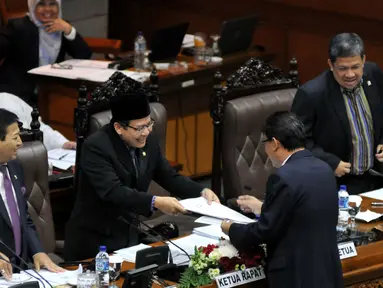 Ketua Badan Anggaran DPR Ahmadi Noor Supit memberikan laporan pandangan fraksi terhadap RAPBN 2016 kepada Ketua Rapat Taufik Kurniawan (kedua kiri) saat Rapat Paripurna Ke-9 di Kompleks Parlemen, Jakarta, Jumat (30/10/2015). (Liputan6.com/JohanTallo)