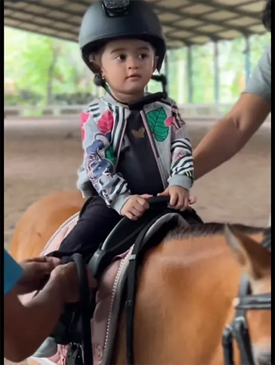 Demi keamanan, baby Guzel juga mengenakan helm untuk pelindung kepalanya.Helm yang dikenakan baby Guzel tampak kebesaran. Meski demikian, ia tampak nyaman saat keliling. [Instagram/marginw]
