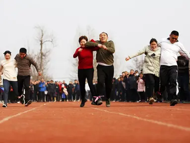 Para petani berpartisipasi dalam perlombaan kaki tiga di Yaogou, Sihong, Suqian, Provinsi Jiangsu, China, 27 Desember 2020. Rangkaian perlombaan seru diadakan setiap tahun sejak 2018 di Yaogou menjelang Tahun Baru. (Xinhua/Xu Changliang)