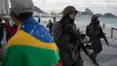 Tentara patroli di pantai Copacabana di Rio de Janeiro, Brasil, (30/7). Ribuan tentara mulai berpatroli di Rio de Janeiro di tengah lonjakan kekerasan di kota terbesar kedua di Brasil. (AP Photo / Leo Correa)