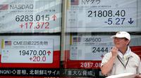 Seorang pria berdiri didepan indikator saham elektronik sebuah perusahaan sekuritas di Tokyo (29/8). Ketegangan politik yang terjadi karena Korut meluncurkan rudalnya mempengaruhi pasar saham Asia. (AP Photo/Shizuo Kambayashi)