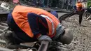 Pekerja mengukur bantalan rel kereta di kawasan Roxy, Jakarta, Selasa (7/1). Penambahan kerikil tersebut dilakukan sebagai bentuk perawatan rutin agar perjalanan kereta tetap aman dan lancar. (Liputan6.com/Immanuel Antonius)