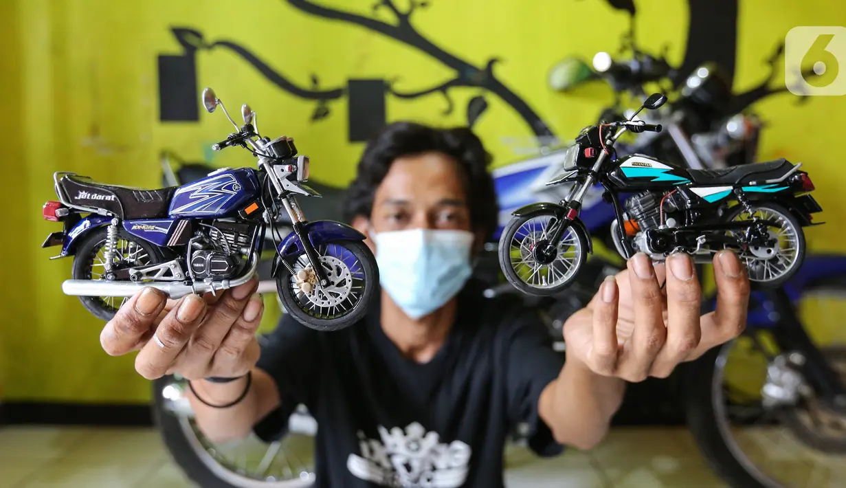 Pengrajin Wawang Kurniawan, menunjukkan dua miniatur motor RX-King dan GL-Pro di Kampung Dukuh, Serua, Tangerang Selatan, Sabtu (17/10/2020). Miniatur motor yang terbuat dari barang bekas paralon, kaleng minuman mulai digeluti sejak tahun 2018. (Liputan6.com/Fery Pradolo)