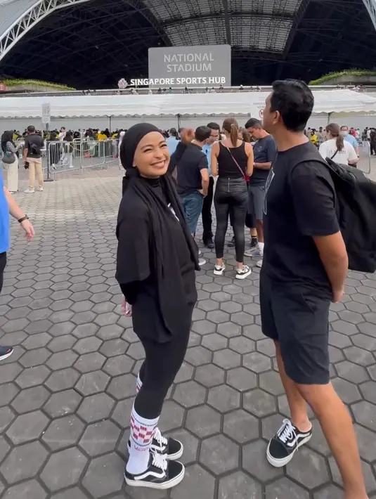 Tantri Kotak tampil serba hitam saat nonton Coldplay. Ia mengenakan t shirt oversize dipadukan kerudung panjang, celana ketat, kaos kaki putih panjang, dan sepatu Vansnya. [@tantrisyalindri]