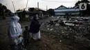 Warga Pancoran Buntu usai Sholat Id diantara reruntuhan akibat penggusuran rumah merka di, Pancoran Buntu II, Jakarta Selatan. Kamis (13/5/2021). Mayoritas umat Muslim di Indonesia melaksanakan Sholat Id sesuai dengan ketetapan pemerintah pada Rabu (13/5/2021). (Liputan6.com/Johan Tallo)