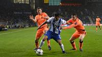 Penyerang FC Porto Porto, Jesus Corona berebut bola dengan pemain Liverpool James Milner dan Andrew Robertson dalam leg pertama babak 16 besar Liga Champions di Stadion Do Dragao, Kamis (15/2). Liverpool menundukkan Porto dengan skor 5-0. (AP/Luis Vieira)