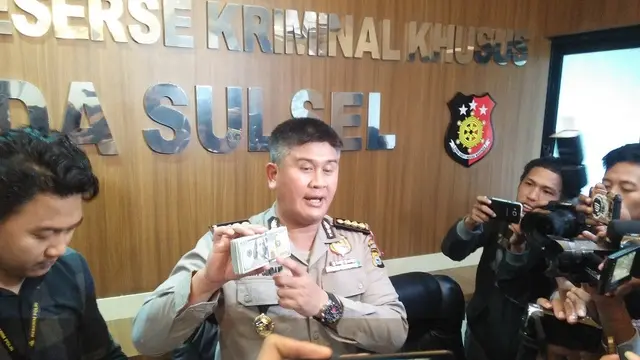 Kabid Humas Polda Sulsel, Kombes Pol Dicky Sondani memperlihatkan barang bukti salah satu kasus korupsi berupa uang dollar (Liputan6.com/ Eka Hakim)