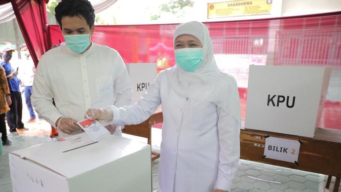 Gubernur Jawa Timur Khofifah Indar Parawansa didampingi putranya, menyalurkan hak pilihnya pada Pilkada Kota Surabaya 2020. (Liputan6.com/Dian Kurniawan)