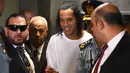 Mantan pemain timnas Brasil, Ronaldinho (tengah) tiba di Asuncion's Justice Palace, ibu kota Paraguay, Asuncion, Jumat (6/3/2020). Ronaldinho bersama saudara laki-lakinya berurusan dengan pihak berwenang Paraguay karena menggunakan paspor palsu untuk memasuki negara itu. (Norberto DUARTE/AFP)