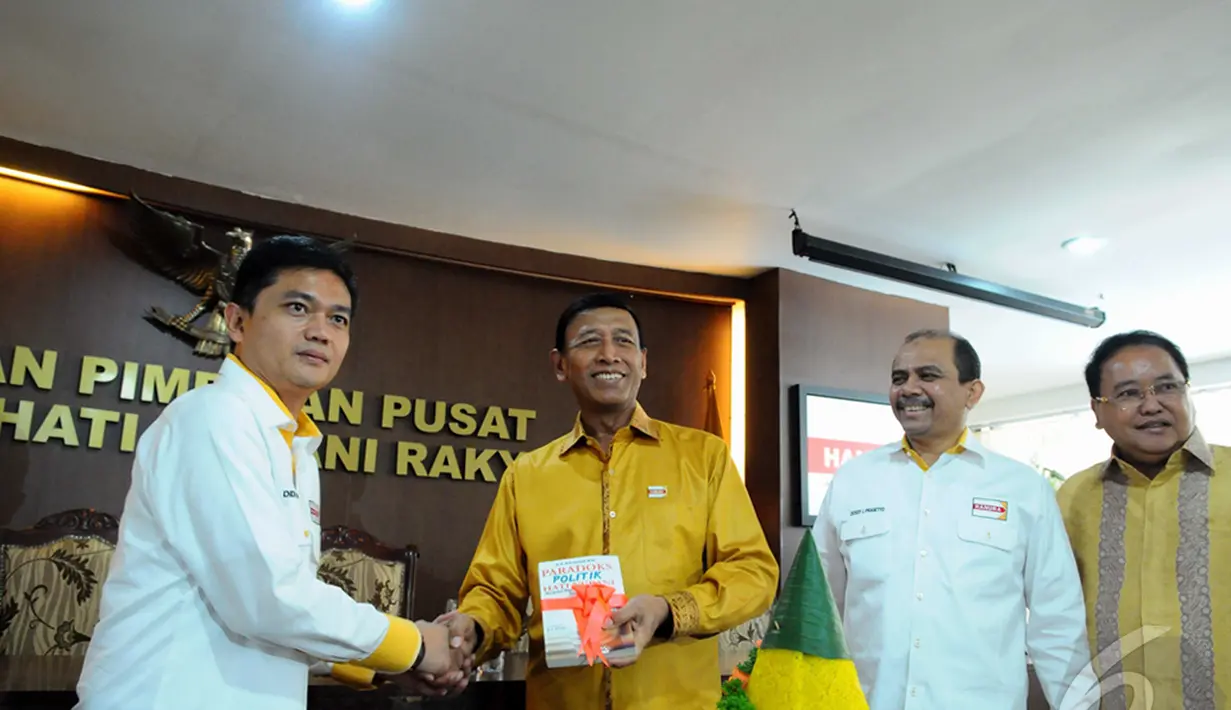 Ketua Umum Partai Hanura Wiranto saat menerima sebuah buku dalam peringatan HUT Ke-8 Partai Hanura, Jakarta,Minggu (21/12/2014) (Liputan6.com/Andrian Martinus)