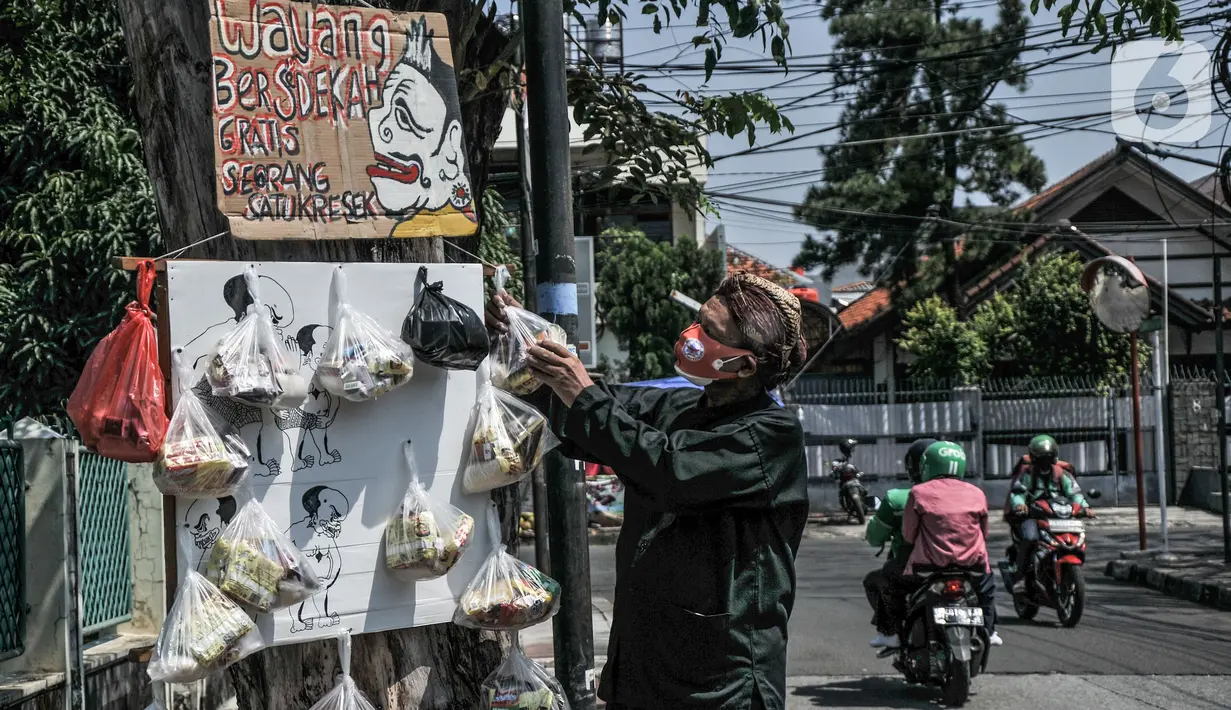 Iskandar (59) menyiapkan paket sembako "Sedekah Cantholan" di kawasan Cawang, Jakarta Timur, Selasa (27/7/2021). Berawal dari niat membantu masyarakat di tengah pandemi Covid-19, Iskandar menggelar "Sedekah Cantholan". (merdeka.com/Iqbal S Nugroho)