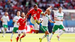 Pemain Wales, Ashley Williams, berebut bola dengan pemain Irlandia Utara, Jamie Ward, pada laga 16 besar Piala Eropa 2016 di Parc des Princes, Paris, Sabtu (25/6/2016) malam WIB. (Reuters/John Sibley)
