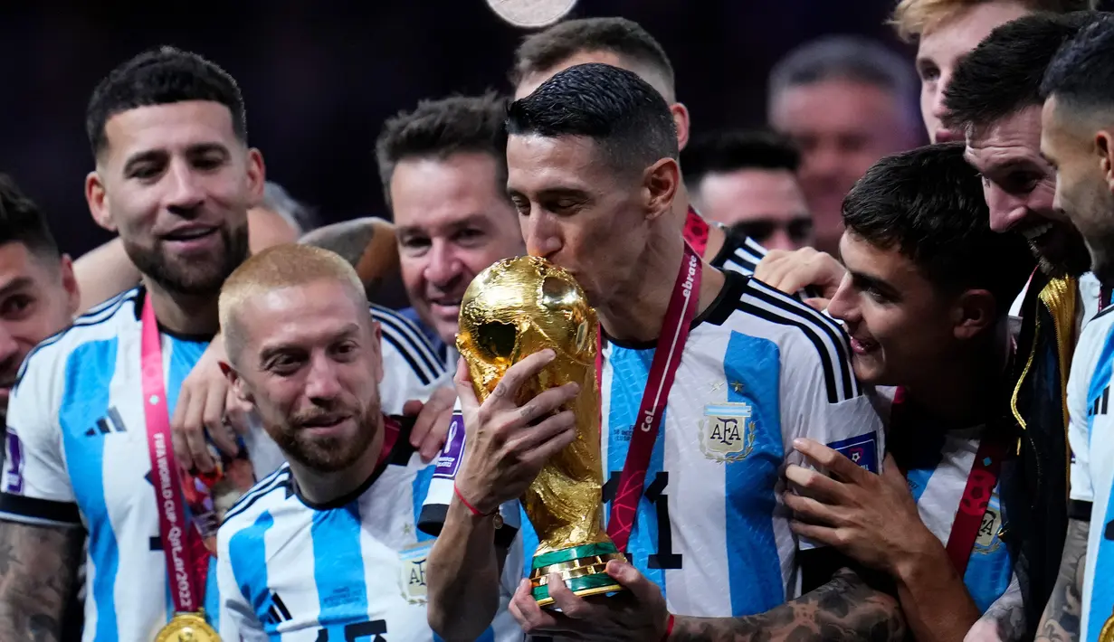 Pemain Argentina Angel Di Maria mencium trofi juara usai mengalahkan Prancis pada pertandingan sepak bola final Piala Dunia 2022 di Stadion Lusail, Lusail, Qatar, 18 Desember 2022. Argentina menang 4-2 dalam adu penalti setelah pertandingan berakhir imbang 3 -3. (AP Photo/Natacha Pisarenko)