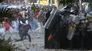 Massa melempar batu ke arah polisi yang membentuk barikade dengan tameng di sekitaran Gedung DPR RI, Jakarta, Senin (30/9/2019). Kericuhan pecah lantaran massa yang kebayakan terdiri dari pelajar tersebut berusaha masuk ke area depan DPR. (Liputan6.com/Angga Yuniar)