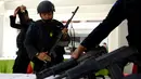 Anggota kepolisian menyiapkan senjata mereka untuk berpatroli di Bandara Ngurah Rai, Denpasar, Jumat (15/1). Pasca serangan di Sarinah, Jakarta, pengelola Bandara Internasional I Gusti Ngurah Rai, Bali perketat pengamanan. (AFP PHOTO/Sonny Tumbelaka)