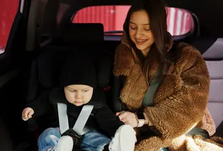 ibu sedang memasangkan car seat untuk anaknya. credits: freepik