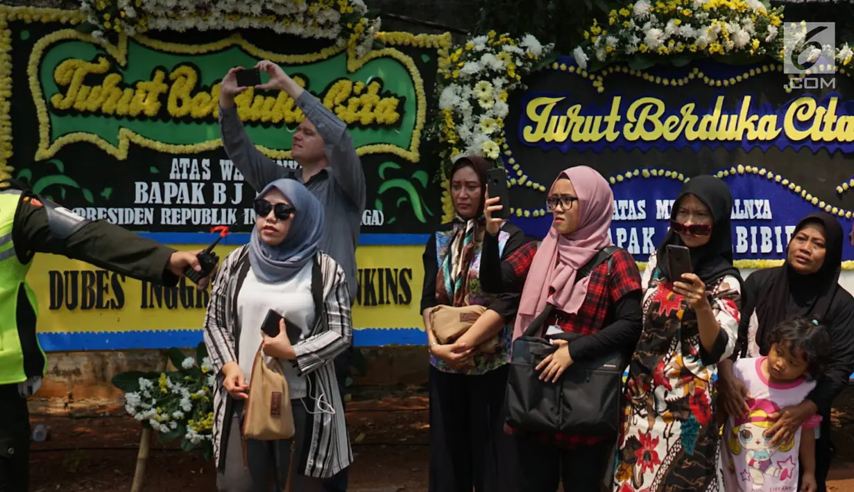 Warga memadati jalan di sekitar rumah duka Presiden ke-3 RI BJ Habibie di kawasan Kuningan, Jakarta, Kamis (12/9/2019). Meninggalnya BJ Habibie menarik simpatik masyarakat untuk datang mengantarkan kepergiaannya yang dimakamkan secara militer di TMP Kalibata, Jakarta Selatan. (Liputan6.com/Immanuel
