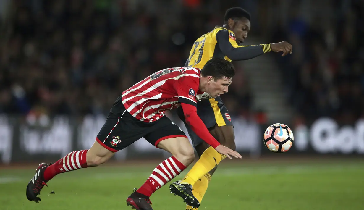 Pemain Arsenal, Danny Welbeck (kanan) berebut bola dengan pemain Southampton,  Pierre-Emile Hojbjerg pada putaran keempat Piala FA musim 2016-2017 di St Mary's Stadium,  (28/1/2017. Arsenal menang 5-0. (Nick Potts/PA via AP)