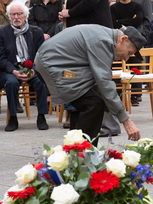 Mantan korban kamp konsentrasi Nazi meletakkan bunga selama upacara peringatan 73 tahun pembebasan di bekas kamp konsentrasi Nazi Mittelbau Dora, Jerman (11/4). (AP Photo / Jens Meyer)