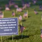 Aktivis dari COVID Memorial Project meletakkan ribuan bendera Amerika berukuran kecil di di halaman National Mall di Washington, Selasa (22/9/2020). Ribuan bendera itu menandai 200 ribu nyawa yang hilang akibat virus corona Covid-19 di Amerika Serikat. (AP Photo/J. Scott Applewhite)