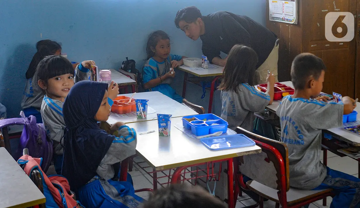Selain makan bergizi gratis, Gibran juga memberikan buku tulis baru kepada para siswa. (merdeka.com/Arie Basuki)