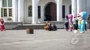Pengunjung berfoto bersama dengan sejumlah badut karakter film kartun di Taman Fatahillah, Jakarta, Rabu (6/5/2015). Tiap harinya seorang badut bisa mengantongi uang Rp 50 ribu hingga Rp 150 ribu. (Liputan6.com/Faizal Fanani)