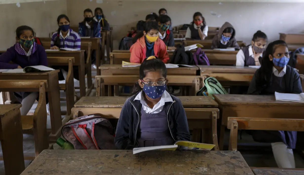 Siswa yang mengenakan masker menghadiri kelas saat sekolah dibuka kembali setelah ditutup selama berbulan-bulan karena pandemi COVID-19 di Ahmedabad, India, Senin (11/1/2021). Negara bagian Gujarat telah membuka kembali sekolah hanya untuk kelas 10 dan 12. (AP Photo/Ajit Solanki)